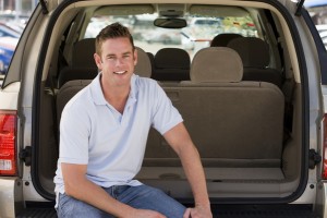 Man sitting in back of van smiling